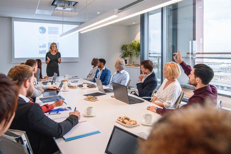 Committee members watching a presentation at a conference table.
